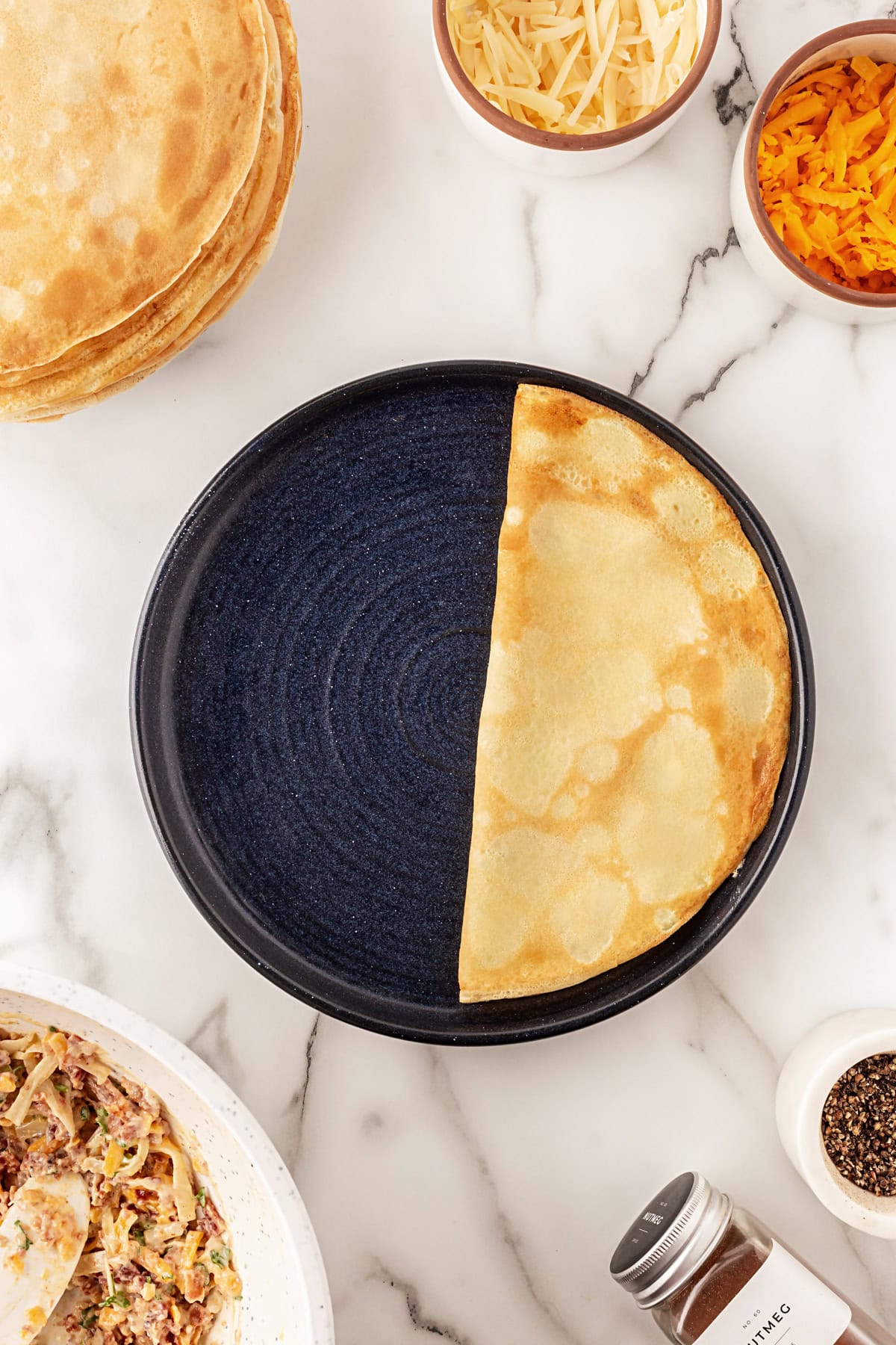 This recipe for Crepes Lorraine is a time-honored treasure that I have been making for over 40 years. Friends and family love this recipe, and I am thrilled to offer it to you also. Crepe folded in half.