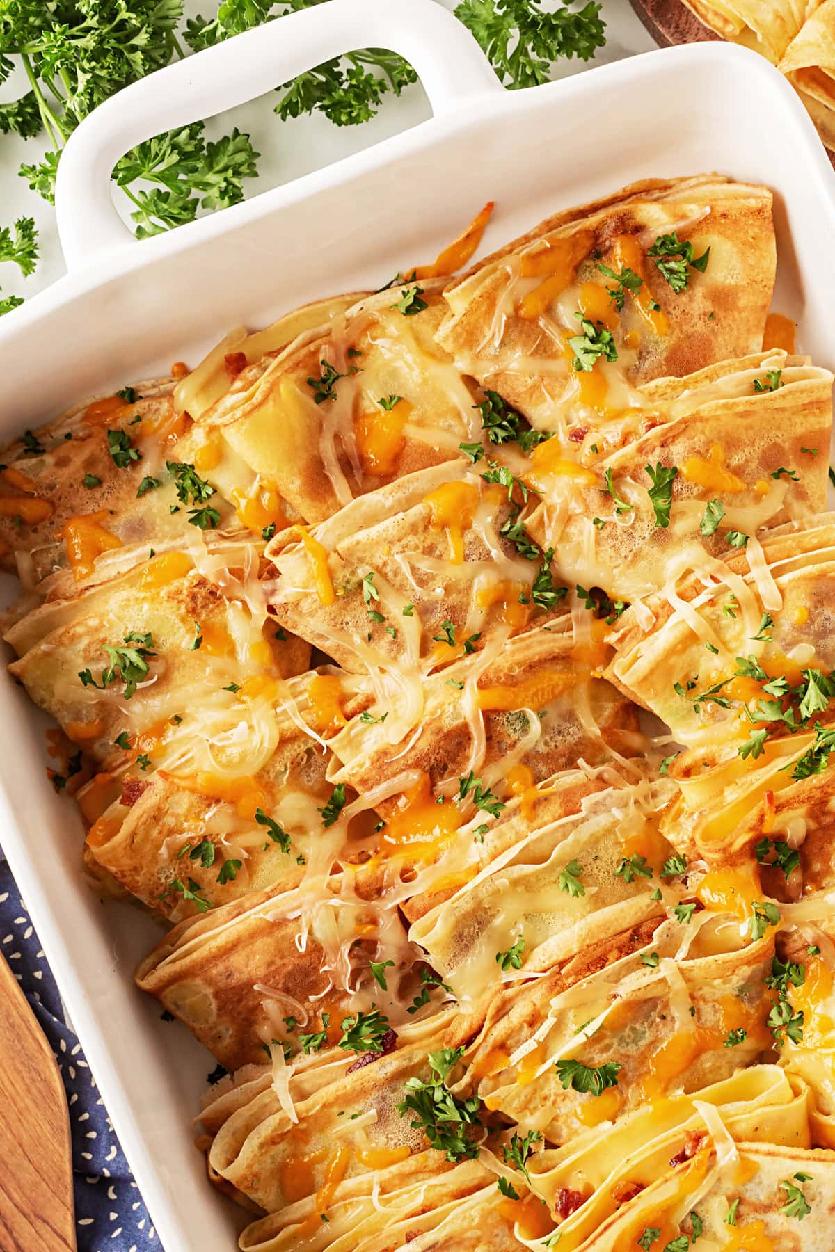 This recipe for Crepes Lorraine is a time-honored treasure that I have been making for over 40 years. Friends and family love this recipe, and I am thrilled to offer it to you also. Crepes Lorraine in a casserole.