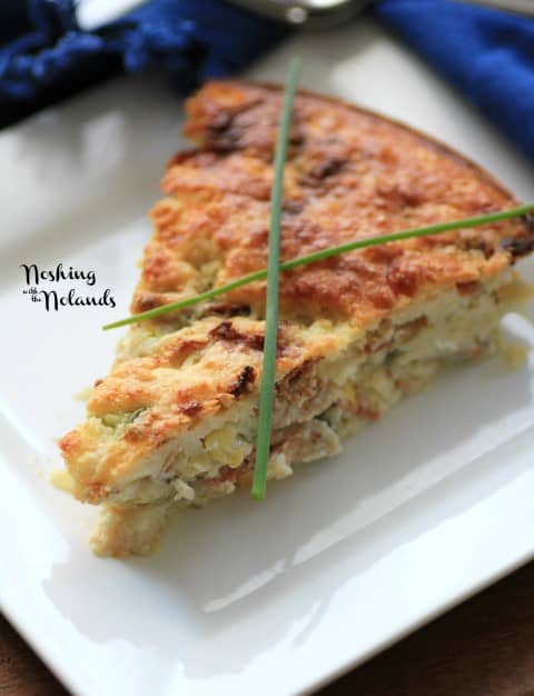 Cheddar-Corn Impossible Pie slice with chives on top on a white plate
