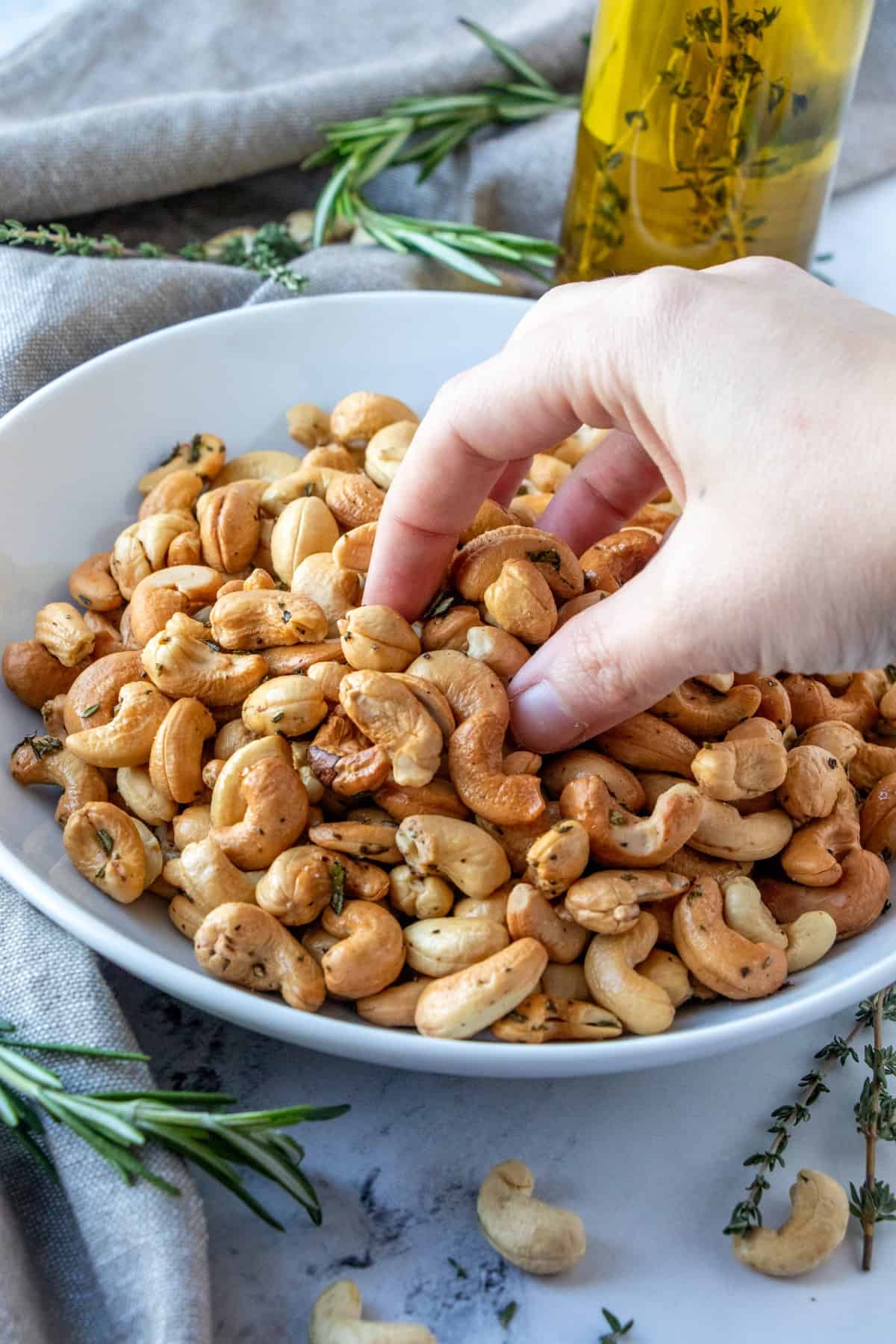 Grabbing Herb Roasted Cashews from a bowl. 
