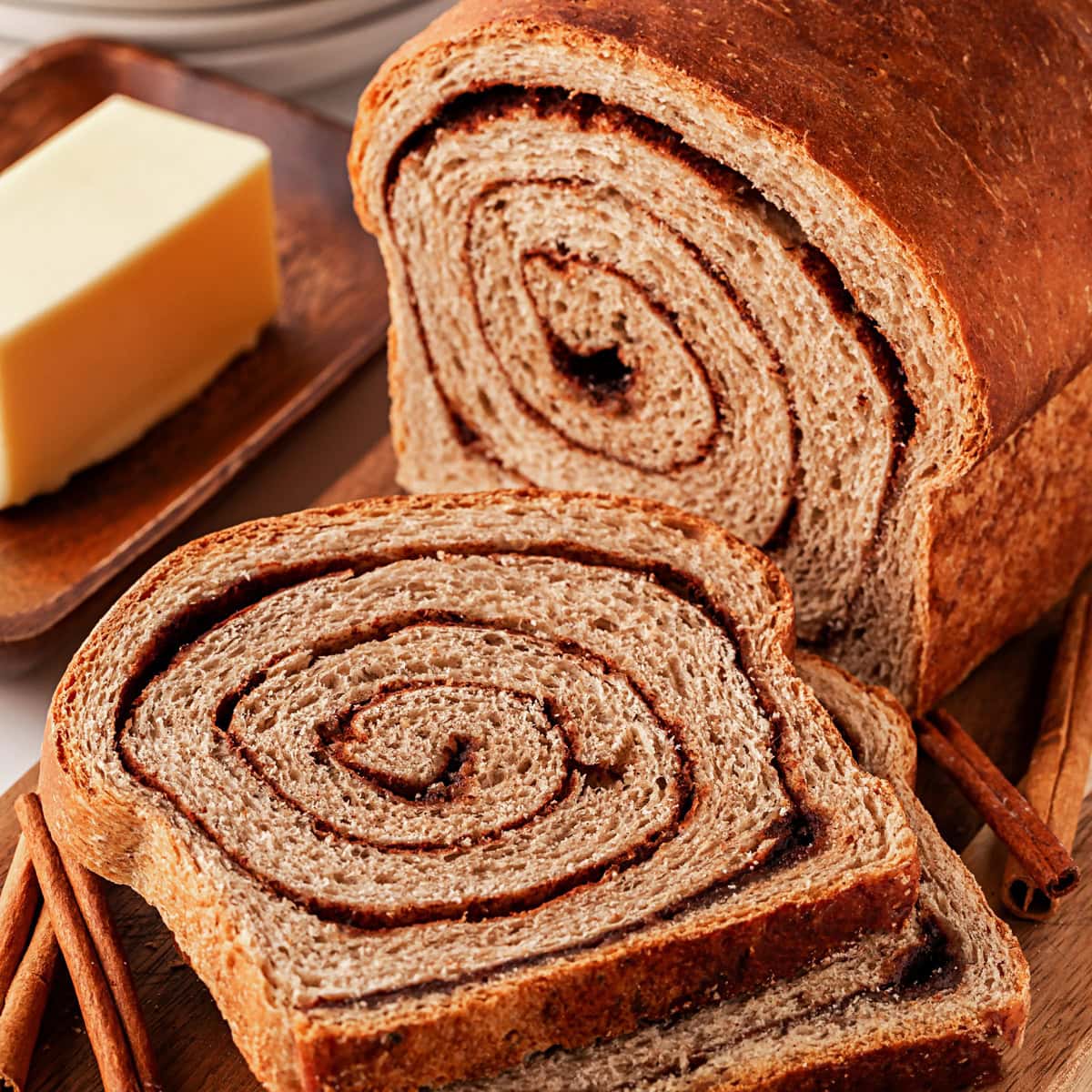 This Cinnamon Swirl Bread is one of the best homemade breads you can make. The bread is light and fluffy with an amazing cinnamon swirl that you will be addicted to. Staring to slice the cinnamon bread.