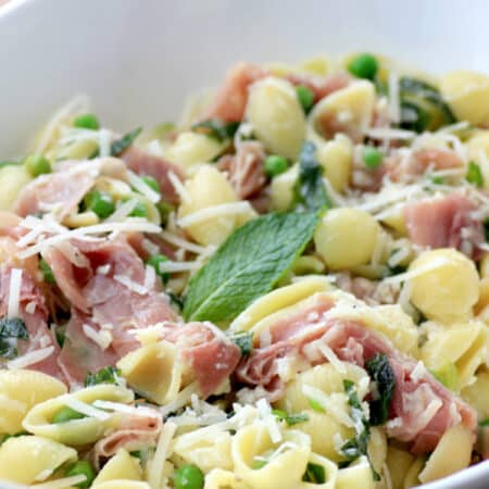 Pasta and proscuitto in a large bowl.