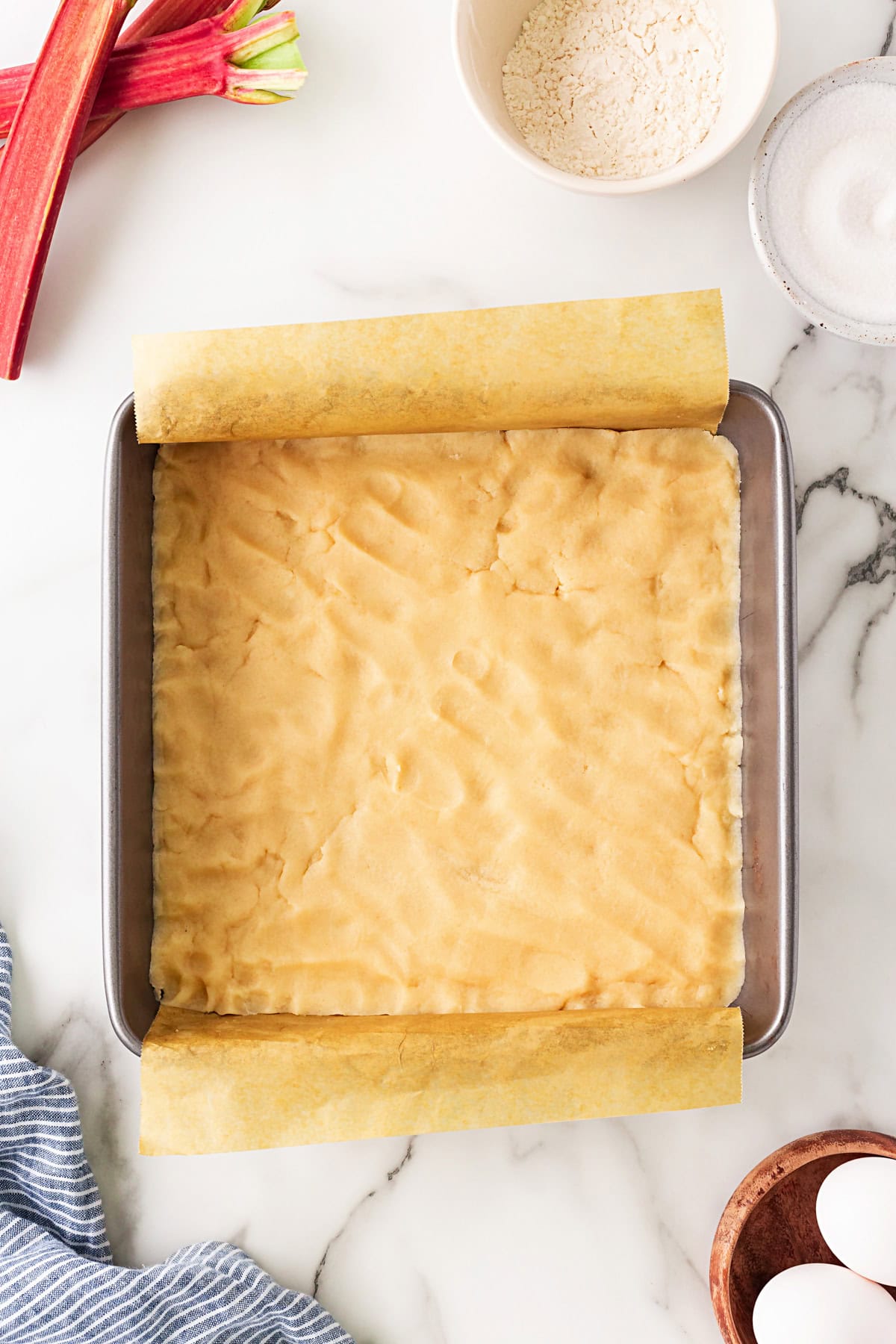 Rhubarb Dream Bars are the perfect rhubarb lover's treat! They are rich and gooey, tart and sweet and make for an exquisite dessert with little effort. Dough in a pan.