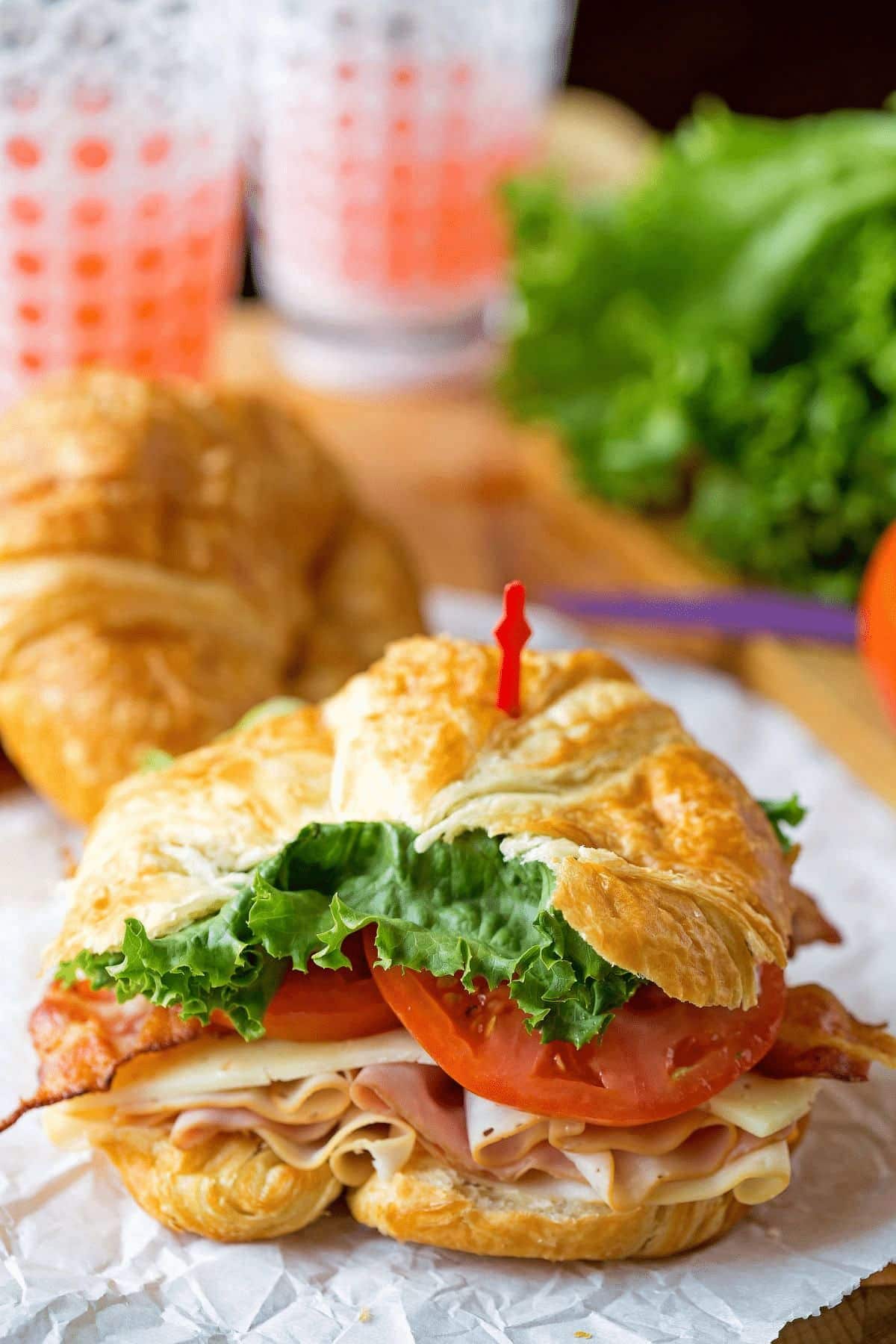 Club Croissant Sandwich served on a napkin with a toothpick.