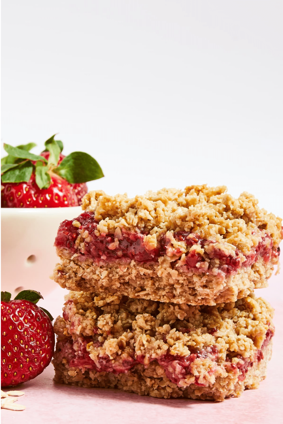 Strawberry Crumble Bars stacked on each other with strawberry.