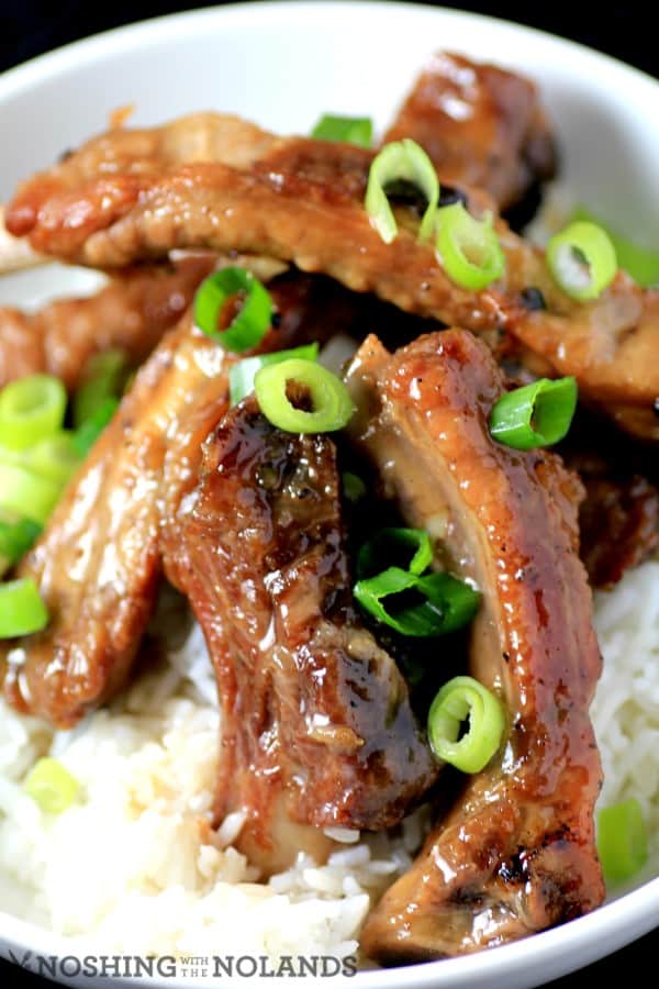 Sweet and Sour Ribs served over white rice garnished with chopped green onions