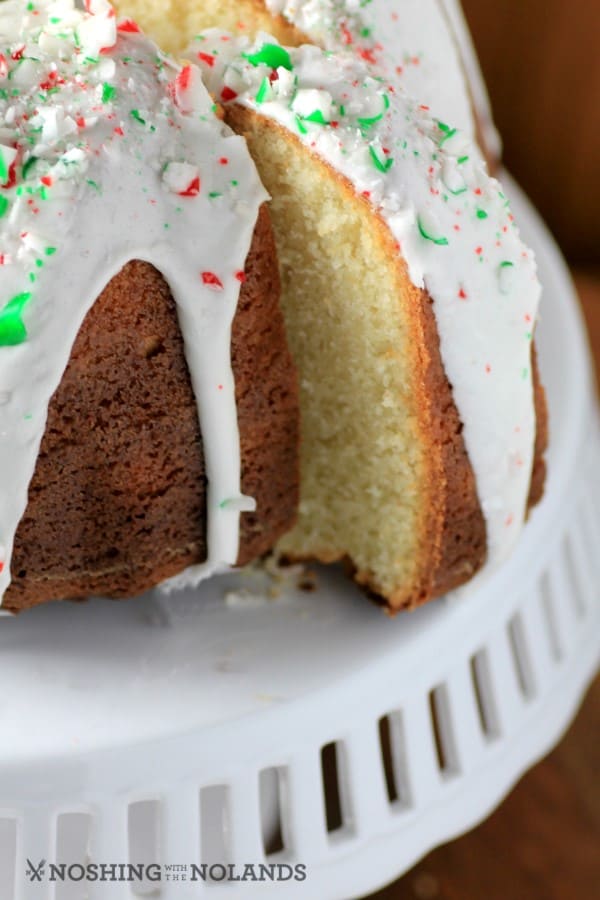 White Hot Chocolate Peppermint Bundt ona white cake stand with a slice cut out