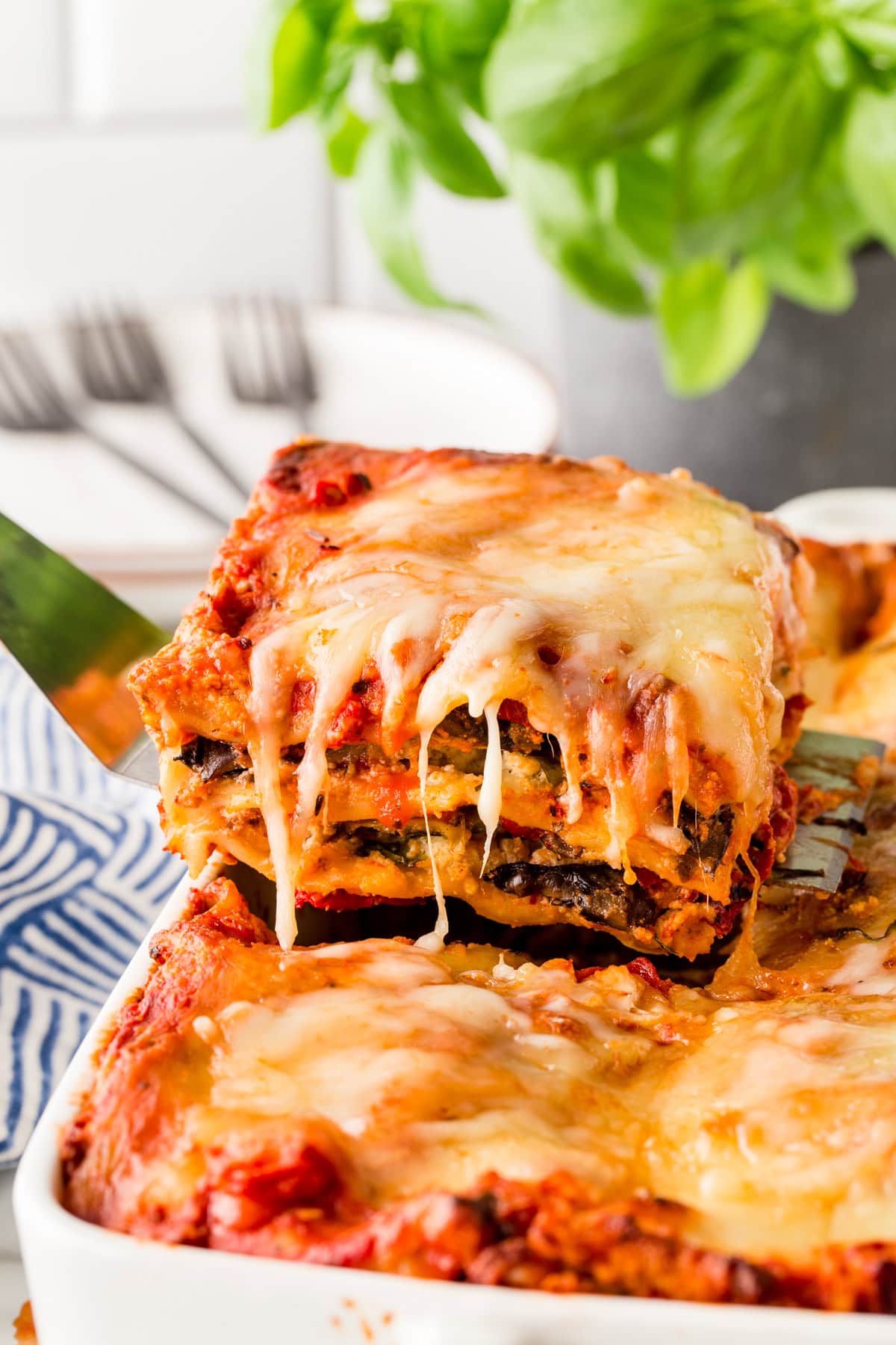 Taking a large slice of lasagna from a pan with a spatula. 