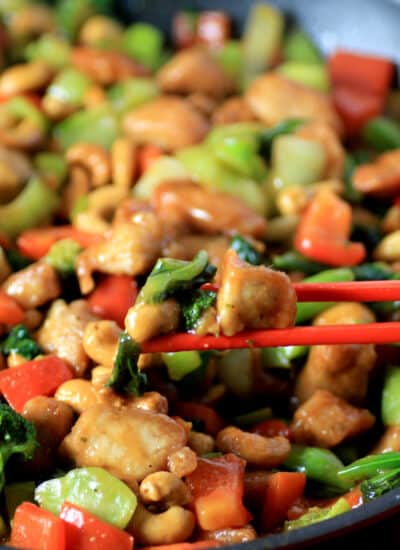 Red chop sticks used to pick up from a pan of stir fry.