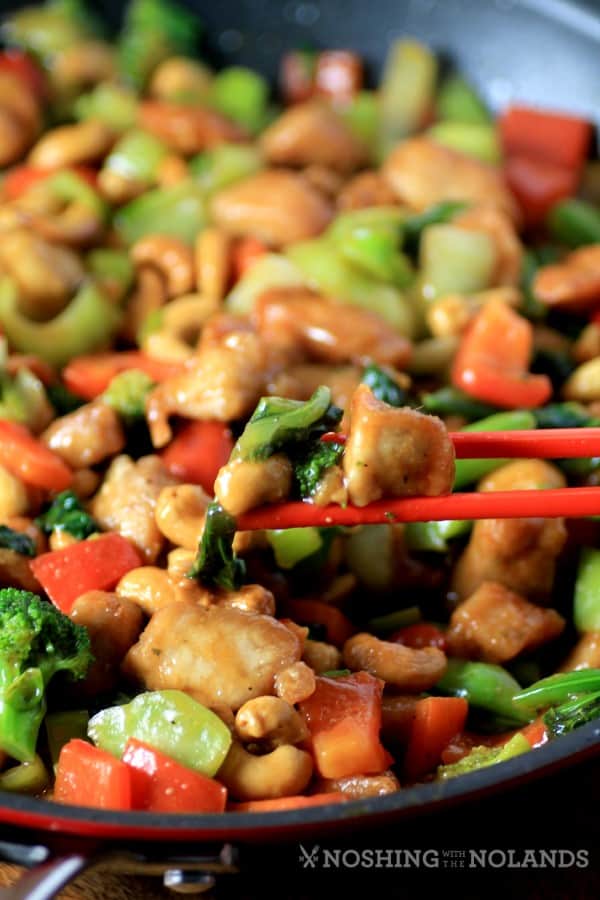 Asian Skillet Stir Fry in a red skillet with chop sticks picking up a bite