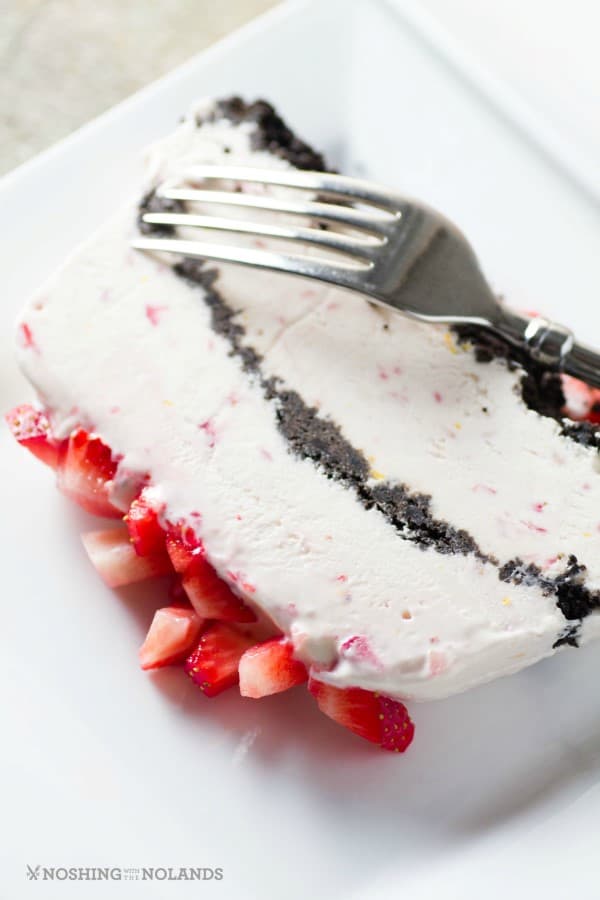 Slice of frozen strawberry easy dessert on a white plate with a fork