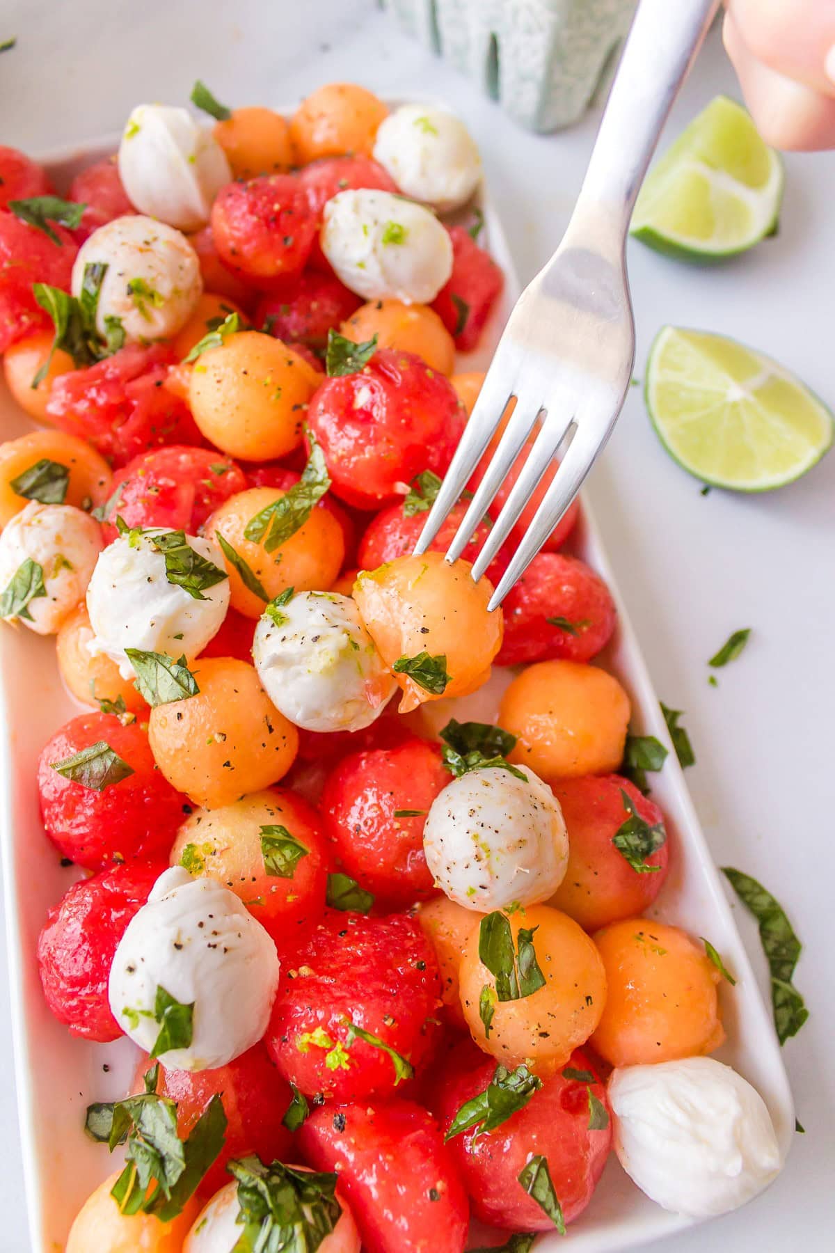 Get outside and enjoy the day with these 50 Picnic Basket Essentials. There is something for everyone to pack the perfect picnic and enjoy family time and the great outdoors. Melon balls and bocconcini on a plate.