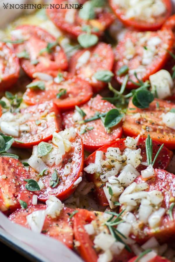 Roasted Italian Tomatoes with onions and herbs on a sheet pan