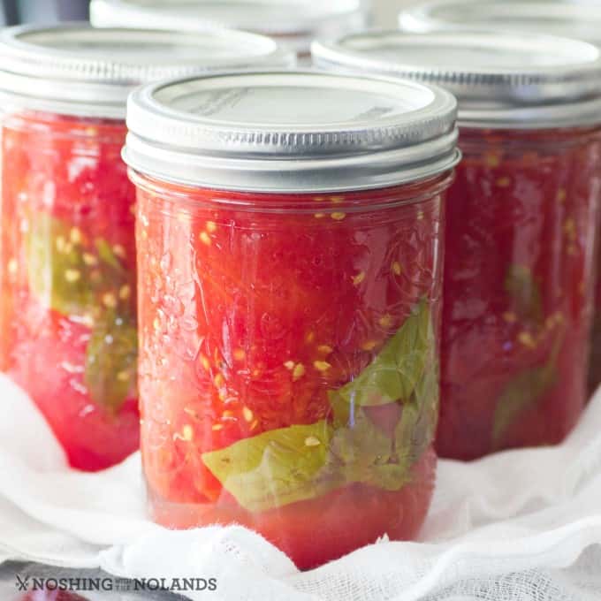 Simple Easy Homemade Canned Tomatoes in jars on a counter on cheesecloth