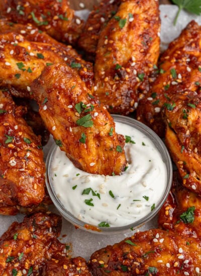 Dipping wings in sauce.