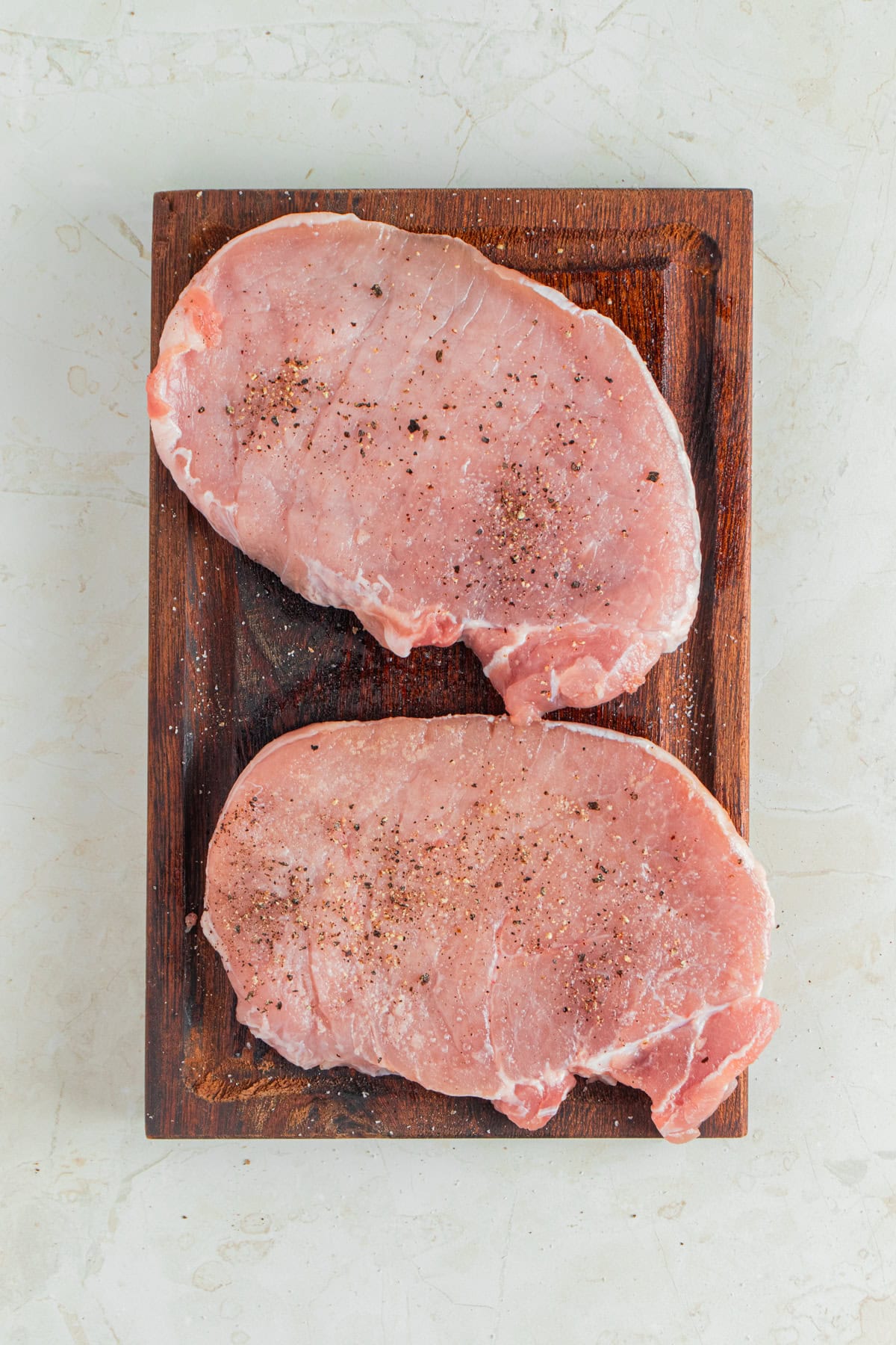 Seasoning boneless pork chops.