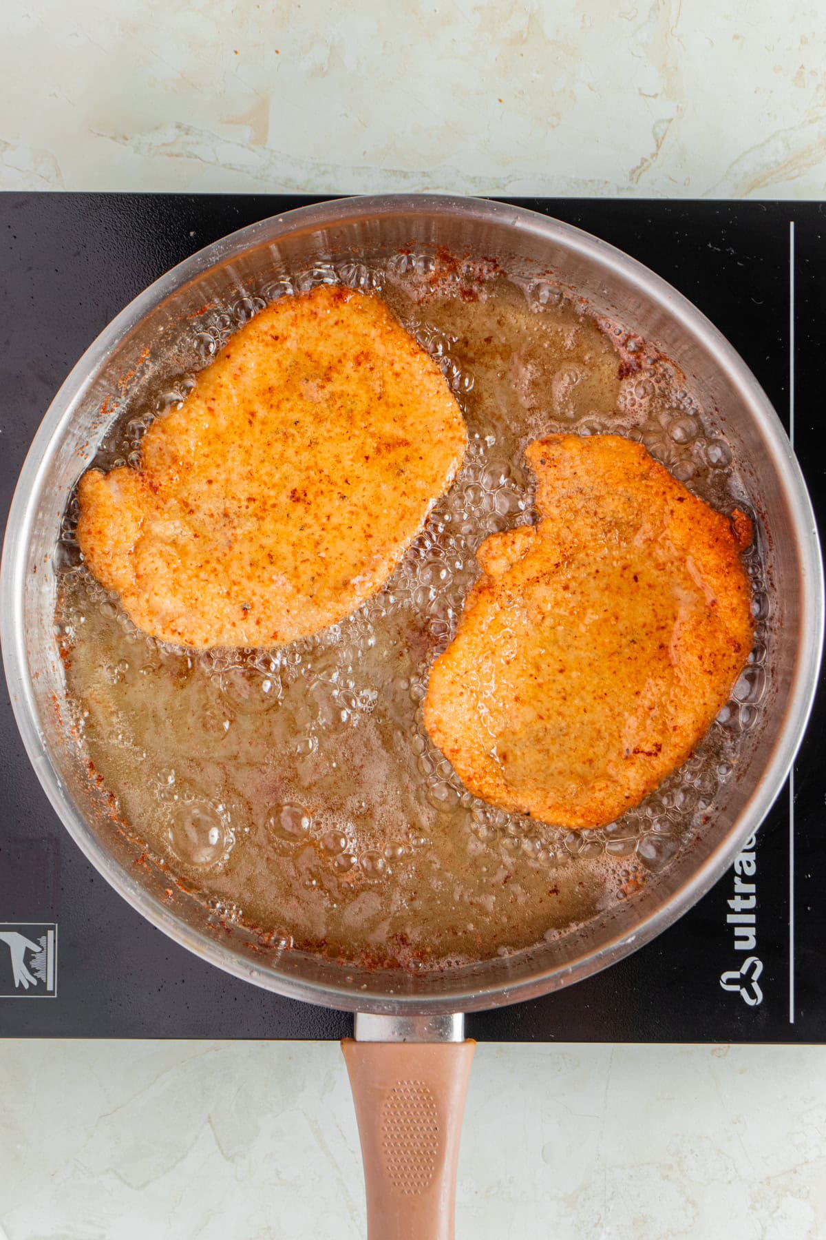 Frying pork schnitzel.