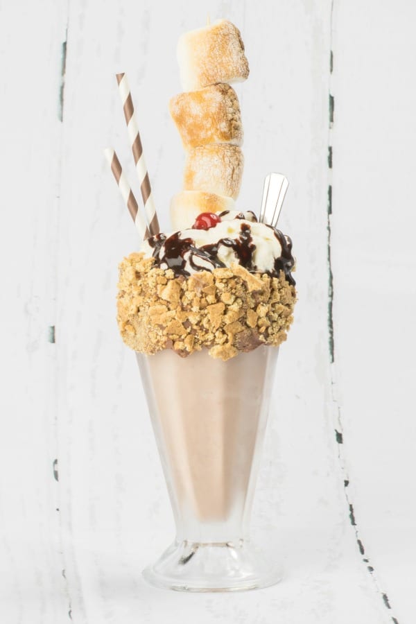 S'mores Milkshake in a tall glass with a straw and spoon