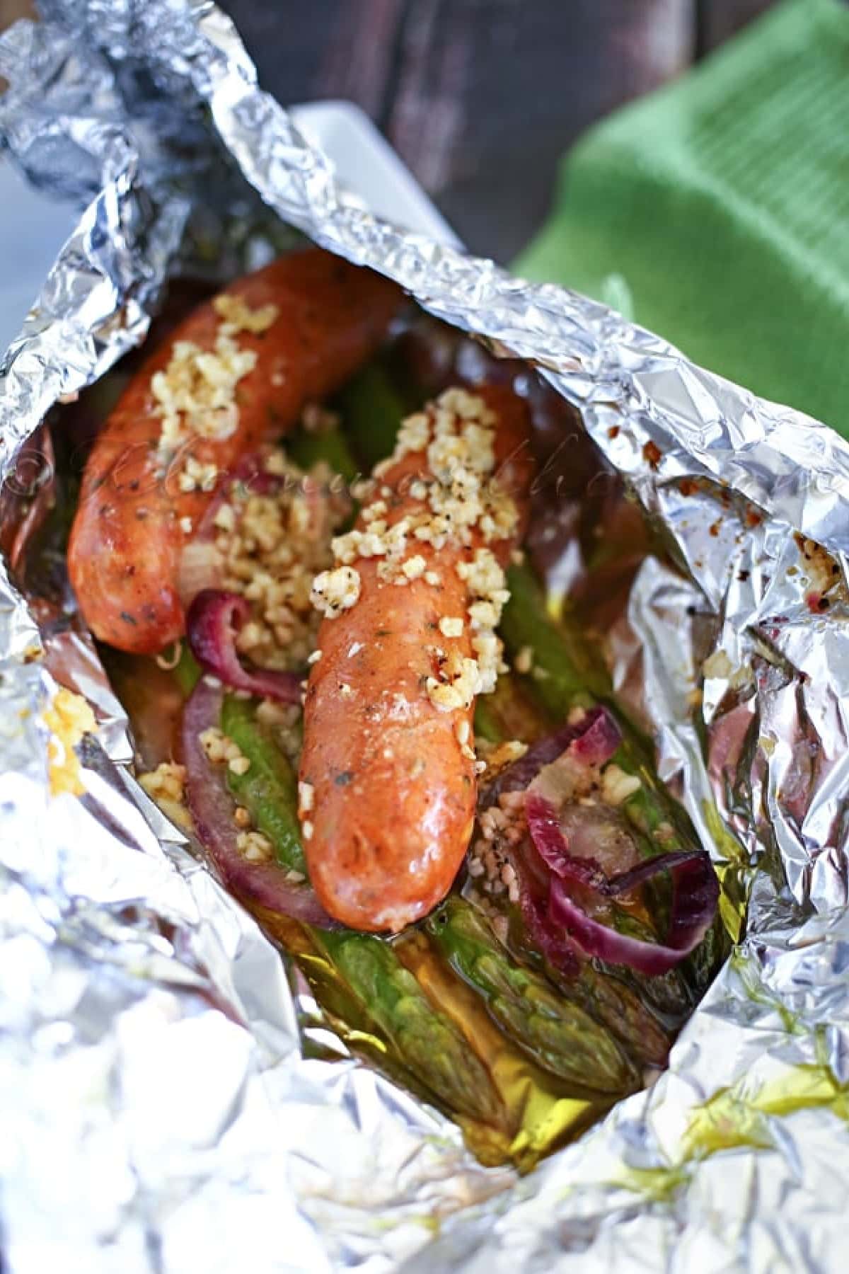 Are you enjoying the great outdoors this summer and wondering what to eat? Try some of these 20 Awesome Campfire Recipes!! Sausage and asparagus in a foil pack.