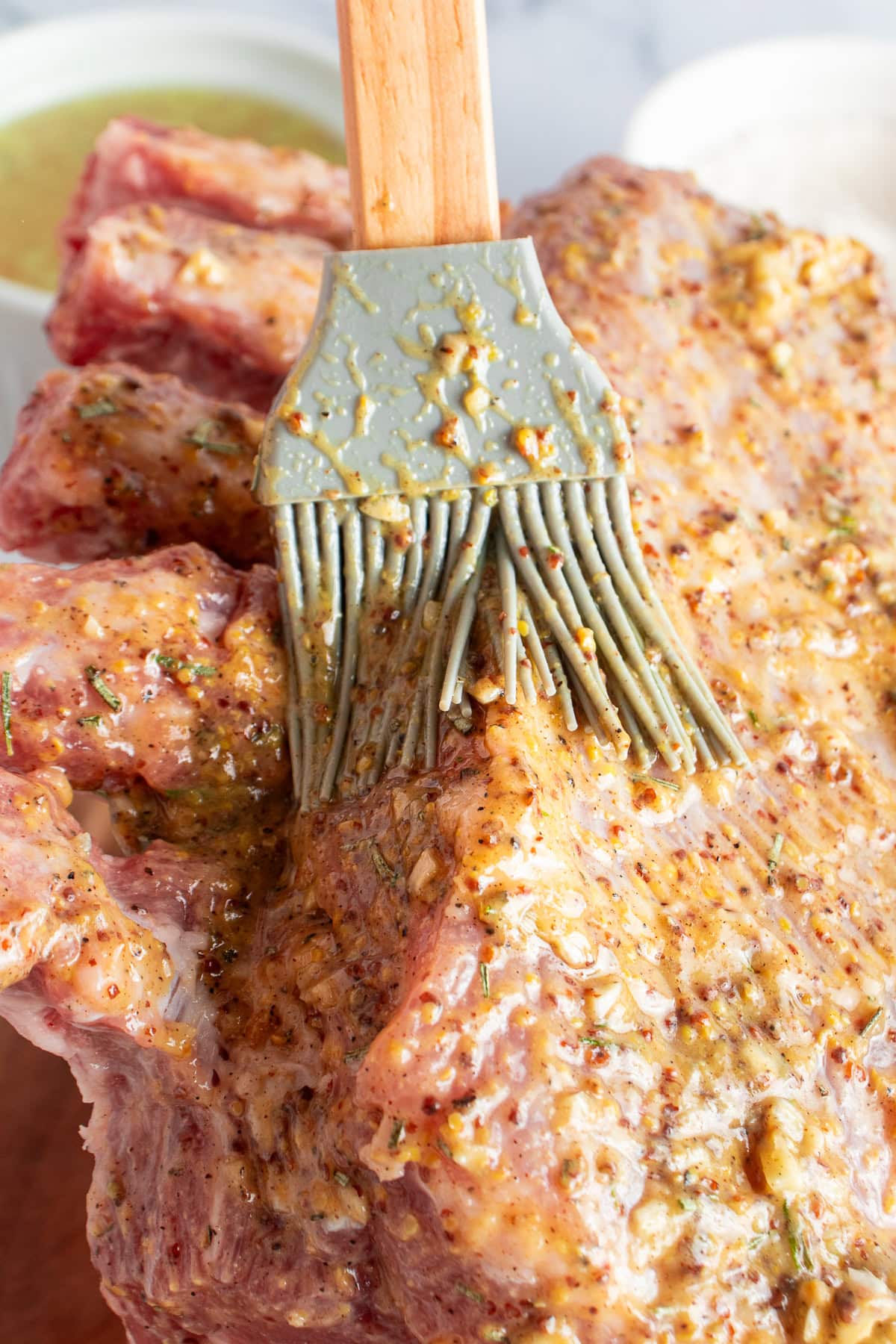 Coating the pork meat with a mustard mixture.