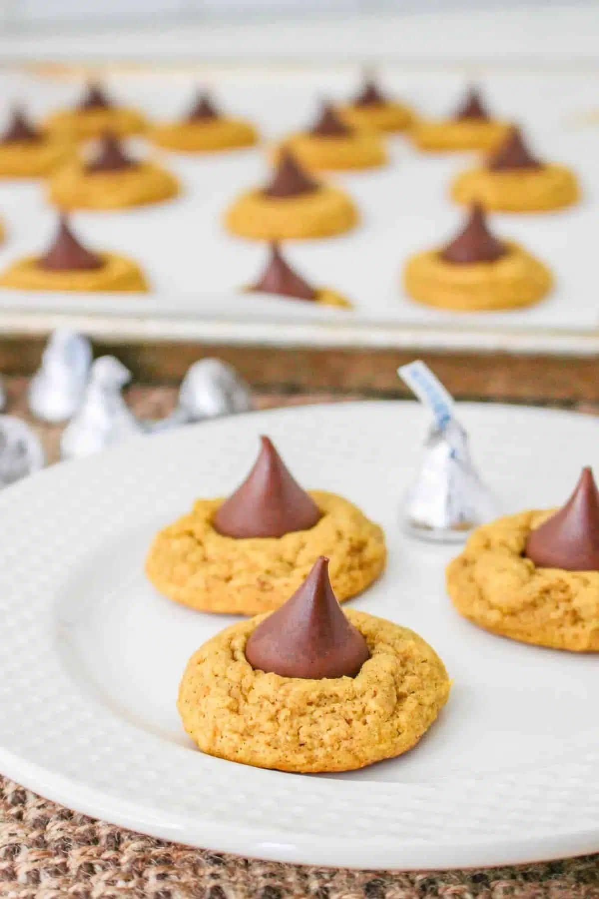 Three pumpkin blossom cookies on a plate. 