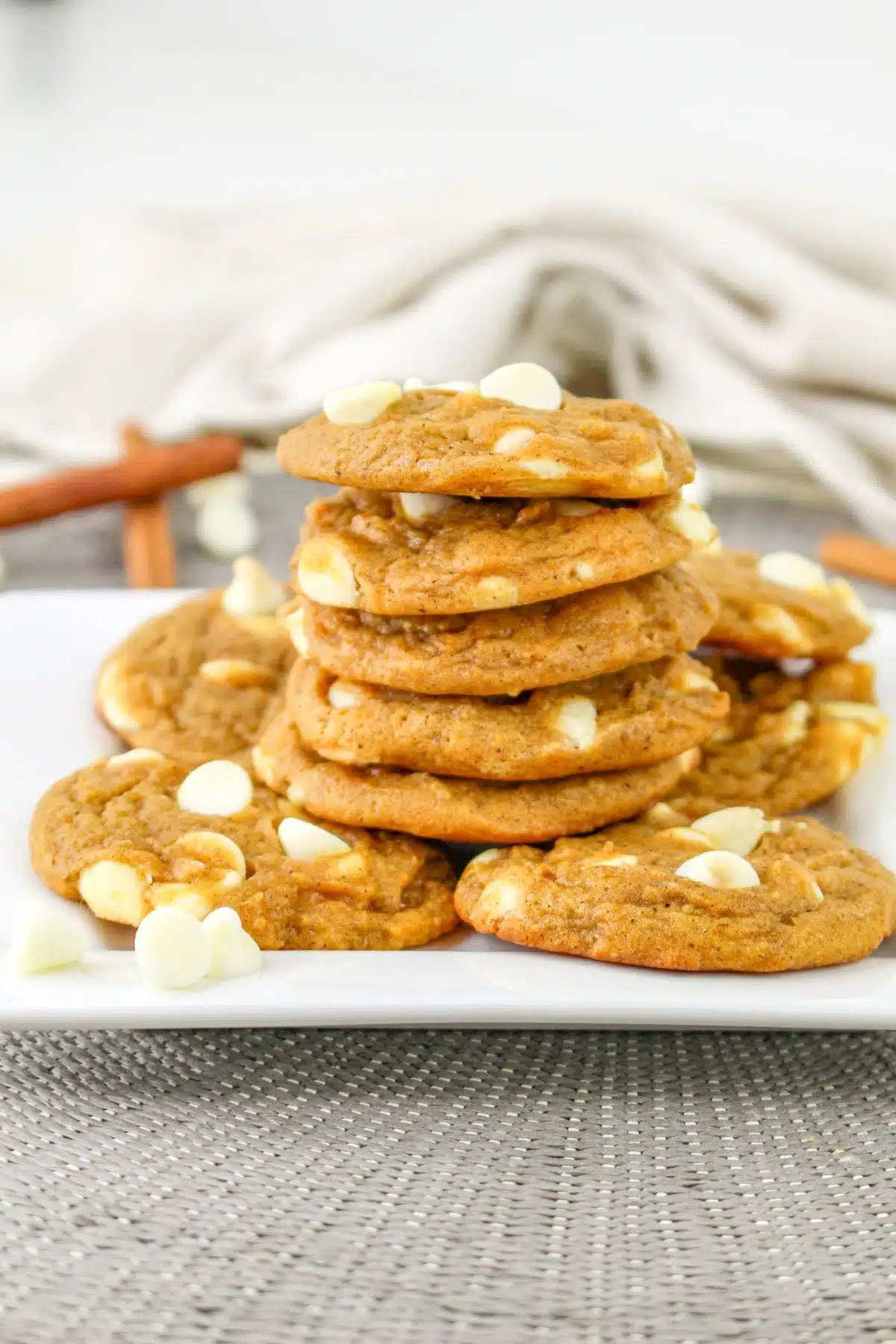 Pumpkin White Chocolate Chip Cookies stacked on a plate. 