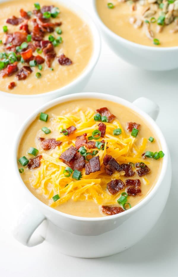 Butternut Cauliflower Soup in a white bowl with bacon on top