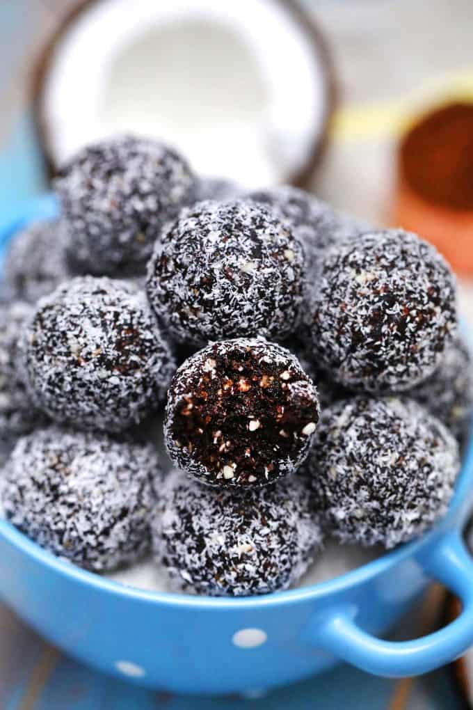 Protein balls in a bowl, one has a bite taken out. 