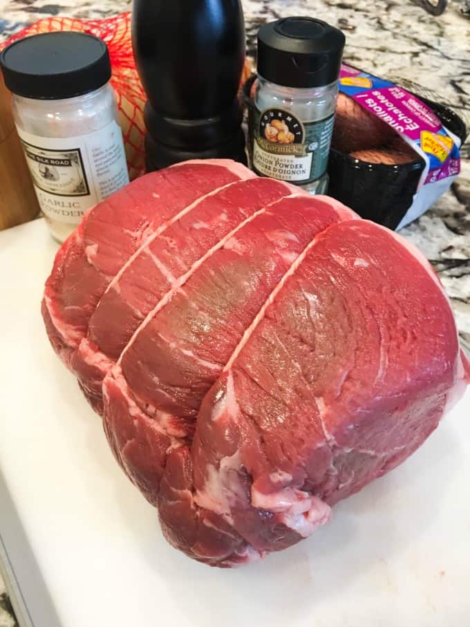 Roast Beef on a cutting board wth spices, onions and shallots