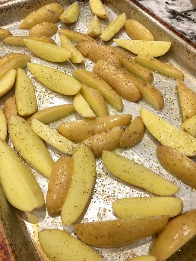 Fingerling potatoes seasoned on a baking sheet
