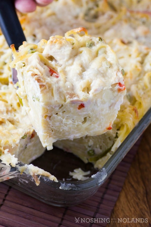 Turkey Cheesy Alsfredo Casserole sliced in a square on a spatula coming from the pan