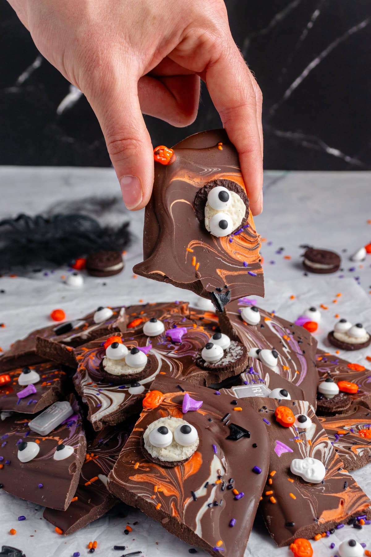 Halloween Bark piled high with one piece being taken. 