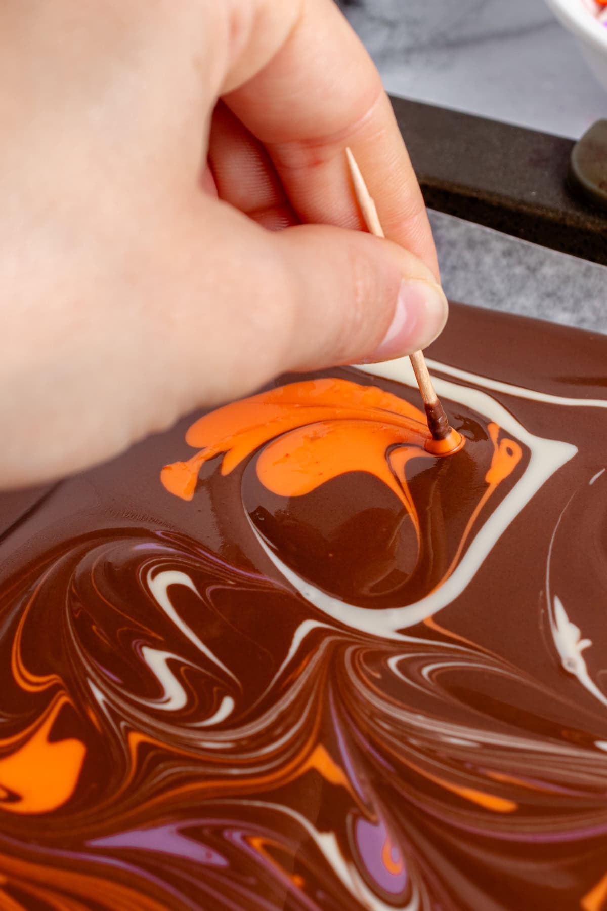 Making the swirl on the chocolate bark with a toothpick.