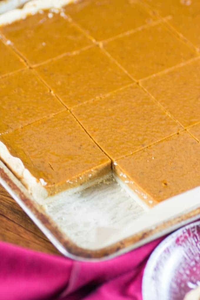 Pumpkin Slab Pie with one piece missing in a jelly roll pan