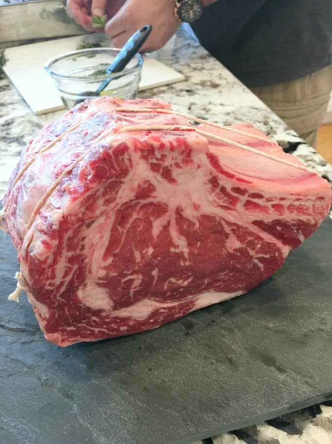 Prime rib uncooked on a black slate board