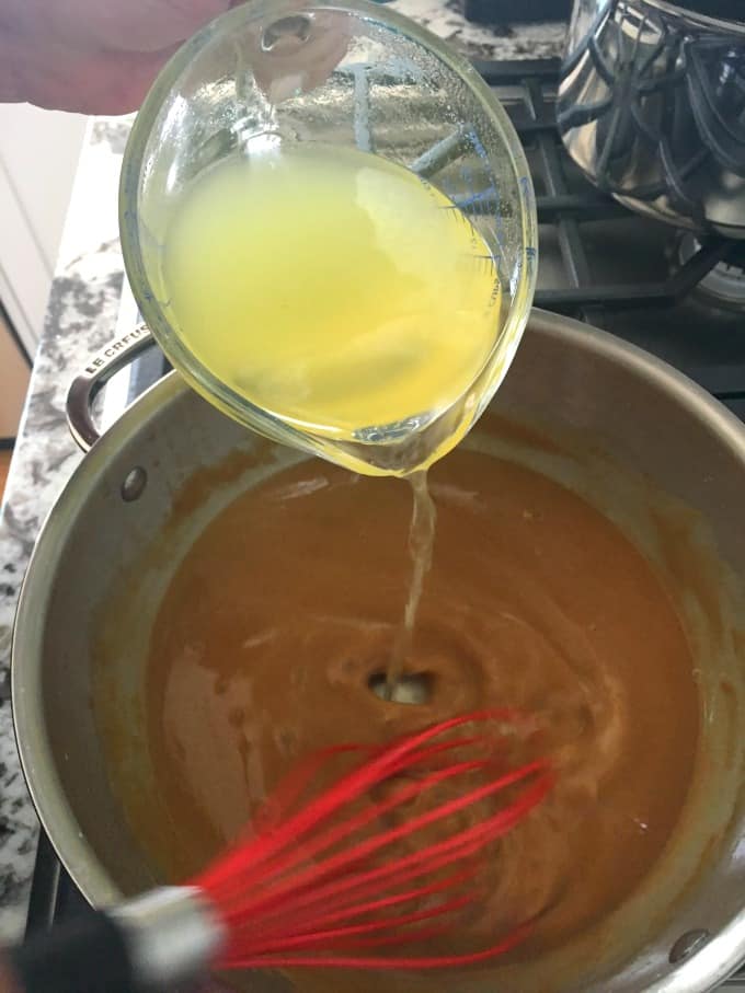 Whisking turkey broth into the pan drippings
