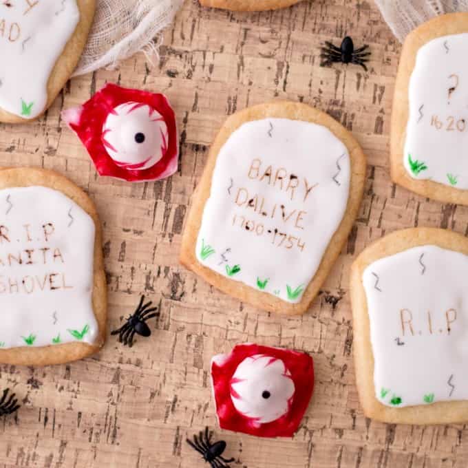 Halloween Tombstone cookies with spiders and eyeballs on cork board