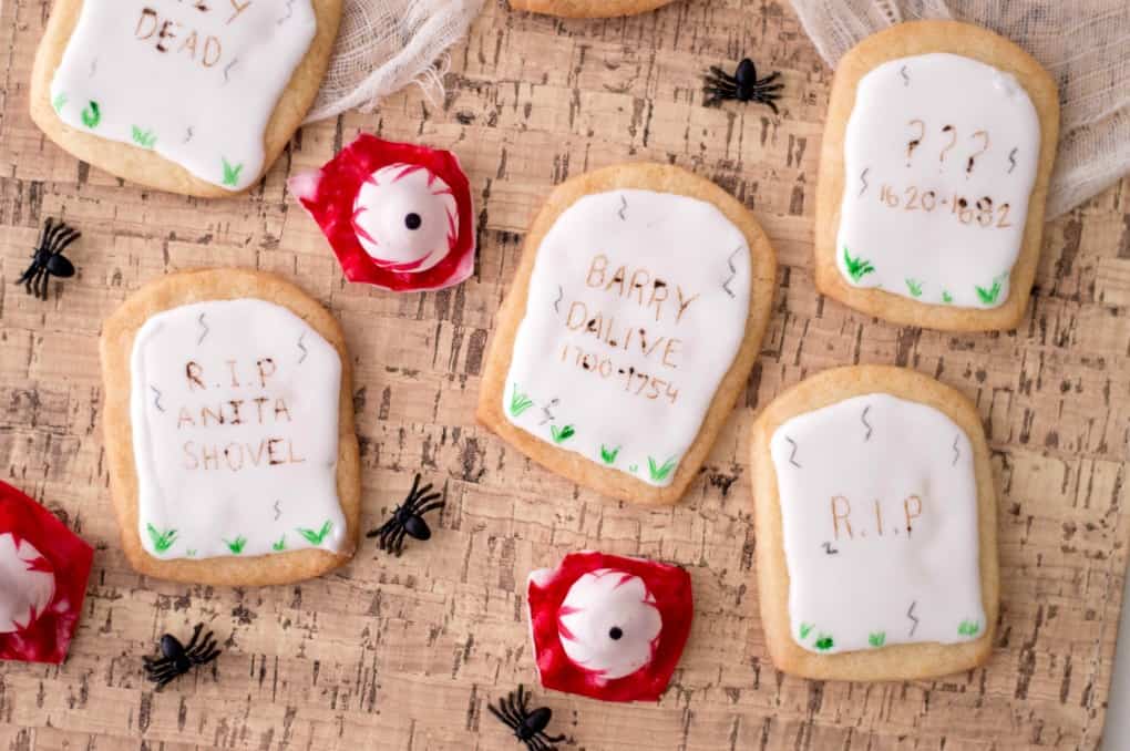 Tombstone cookies with spiders and eyeballs on cork board
