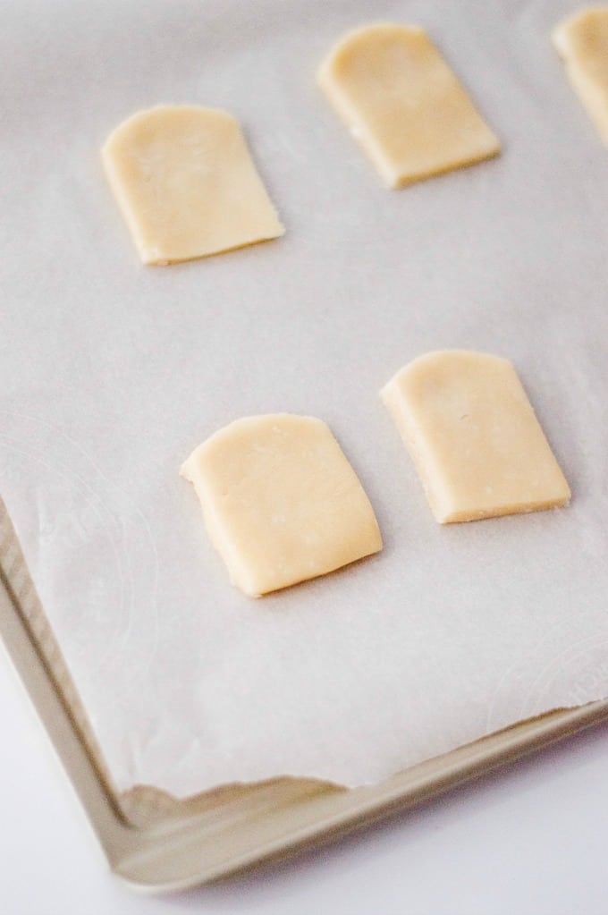 Tombstone cookies on a parchment lined baking sheet