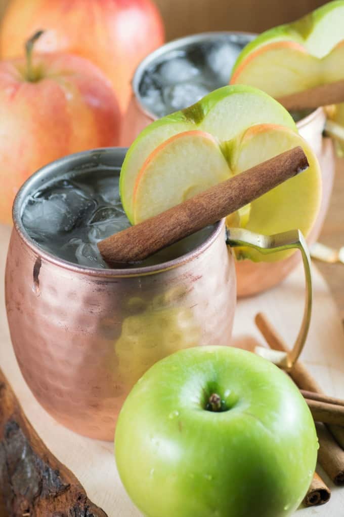 Apple Bourbon Moscow Mule in a copper mug with apple slices. 