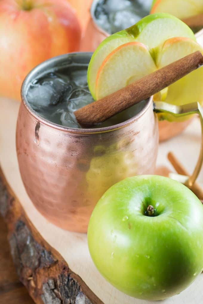 Apple Bourbon Moscow Mule in a copper mug with apple slices. 