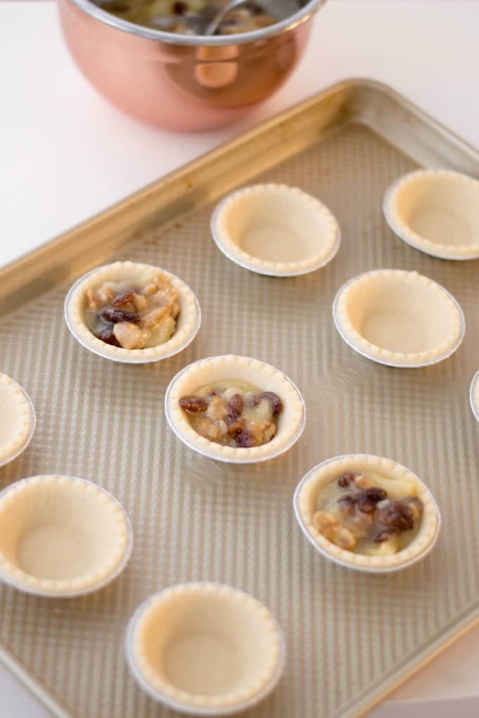 Filling tart shells on a baking sheet