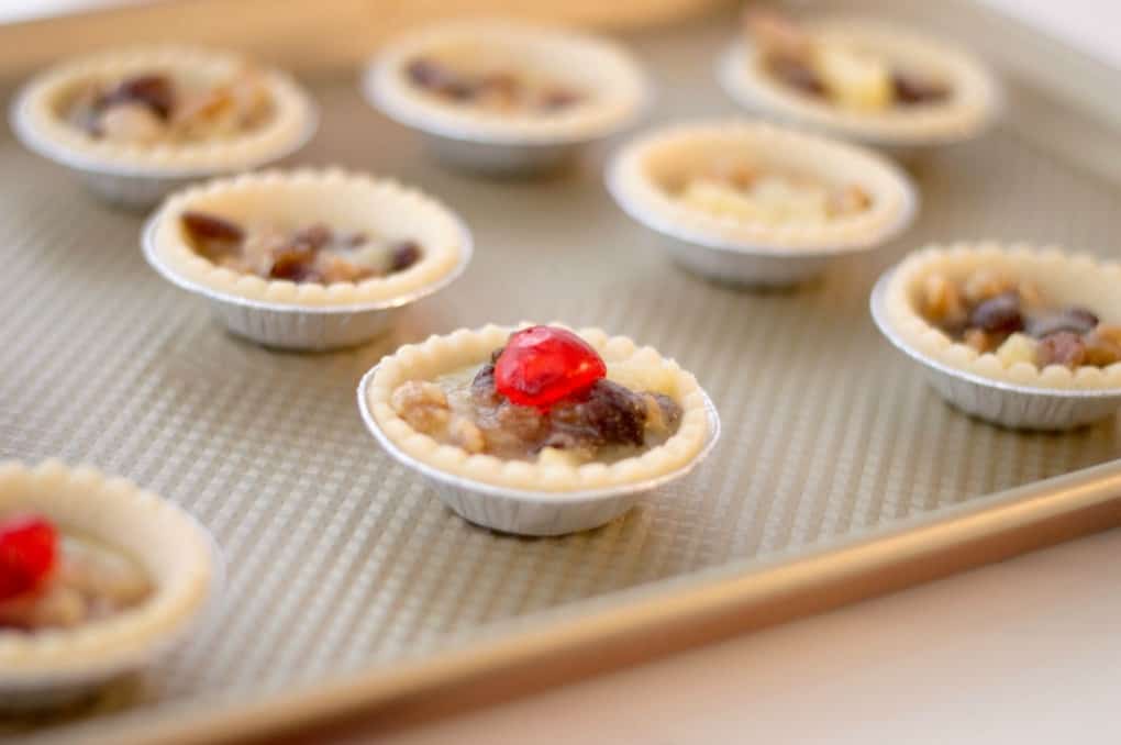 Filled tart shells on a baking sheet