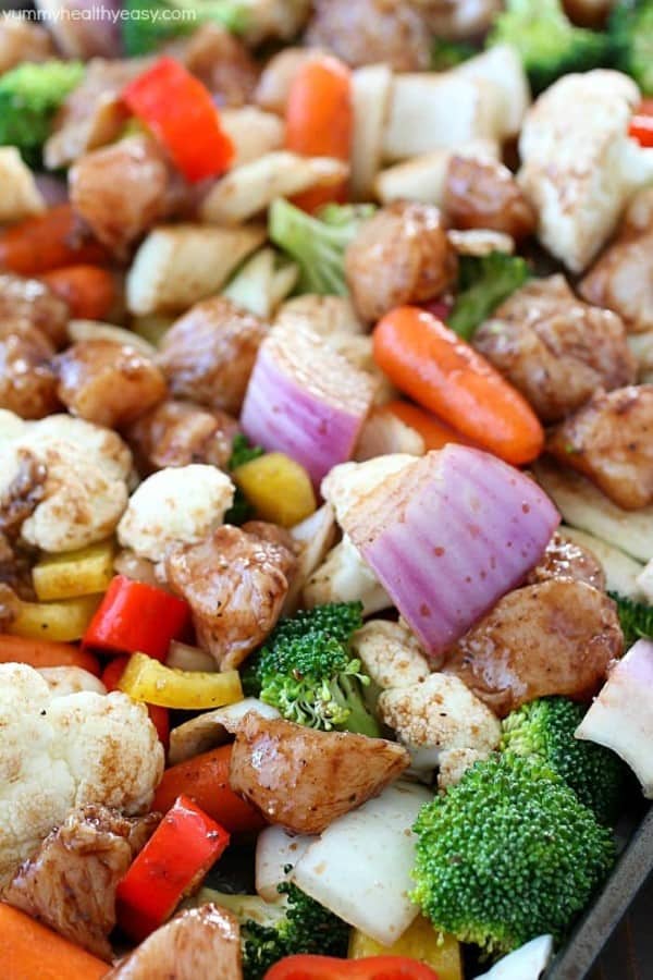 Chopped up chicken and vegetables on a sheet pan