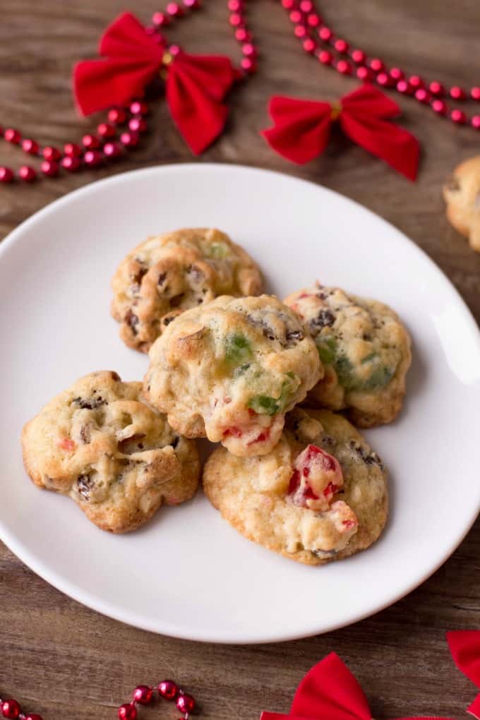 Best Ever Fruitcake Cookies na białym talerzu z dekoracją świąteczną. 