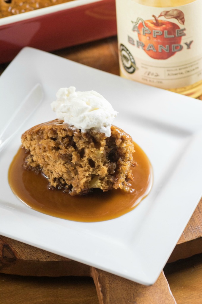 Easy Apple Brandy Sticky Toffee Pudding on a white plate with whipped cream. 