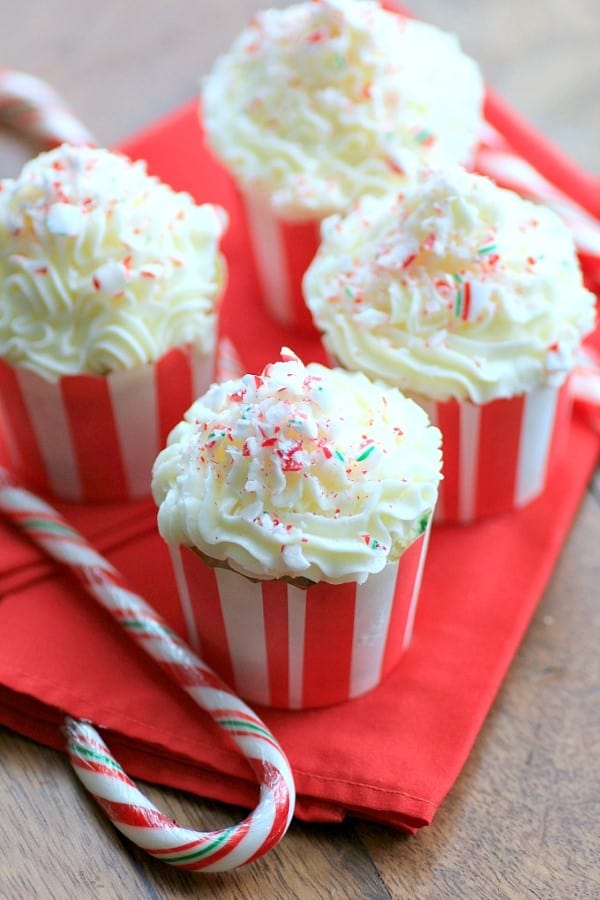 Vanilla Candy Cane Cupcakes with candy canes on a red napkin. 