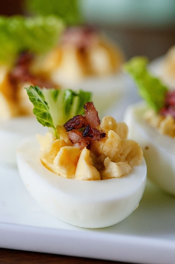 Bacon caesar salad deviled eggs on a white platter