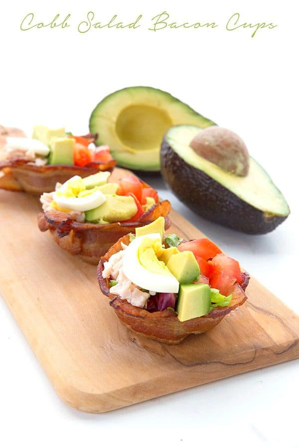 Cobb salad bacon cups on a wooded serving board with a halved avocado