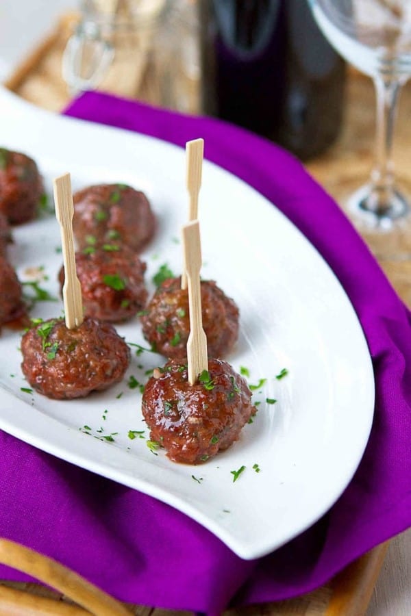 Crock pot meatballs with blackberry chili sauce on a white serving platter